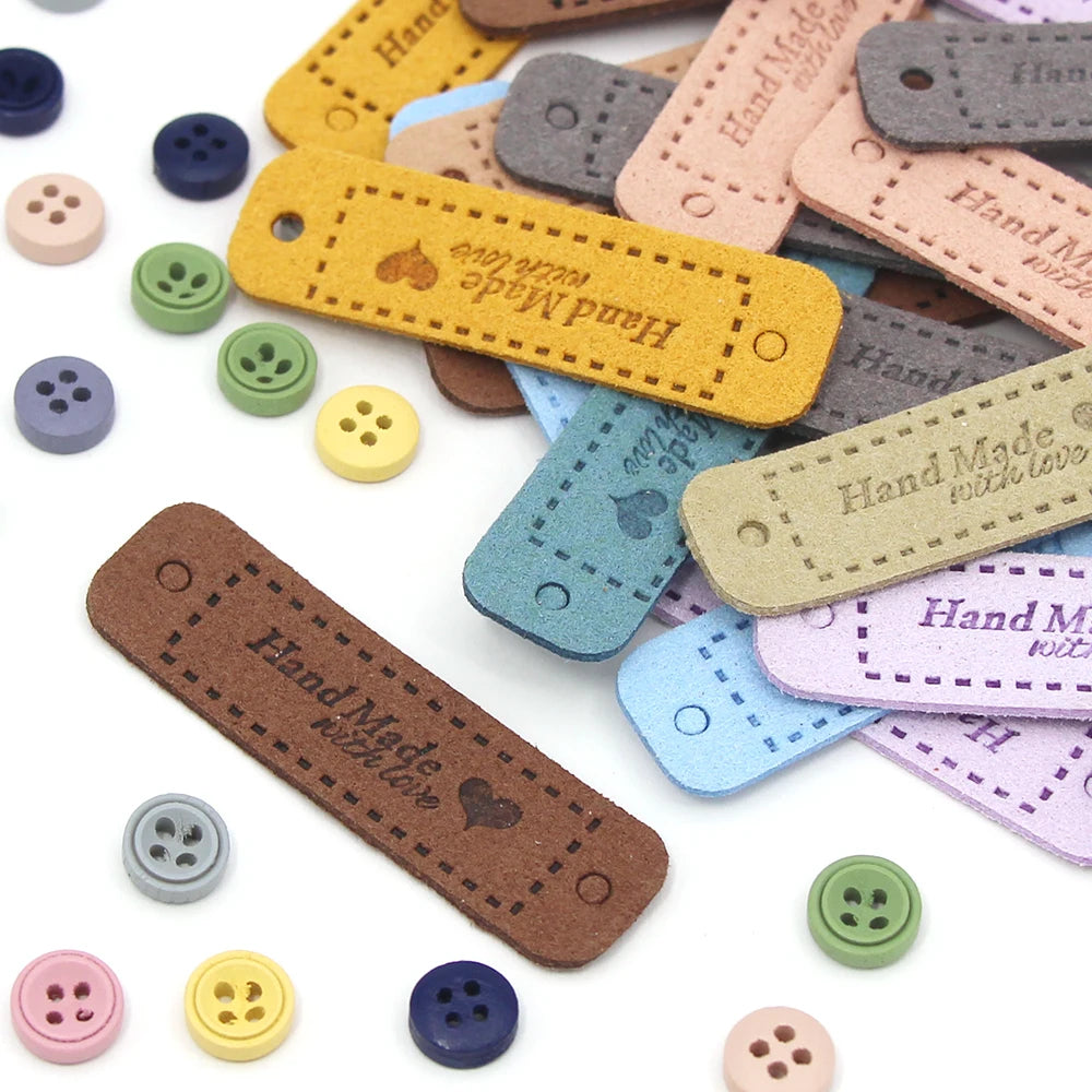 A collection of 20 leather-style handmade with love tags in various colors and shades for crafts and sewing projects.