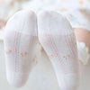 A pair of white floral cotton kids socks with delicate pink flowers