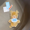 A fluffy orange bear plush toy with a blue heart decoration is shown against a neutral background.