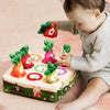 A baby is interacting with a soft pulling carrot sensory toy box featuring various colored fruit shapes.