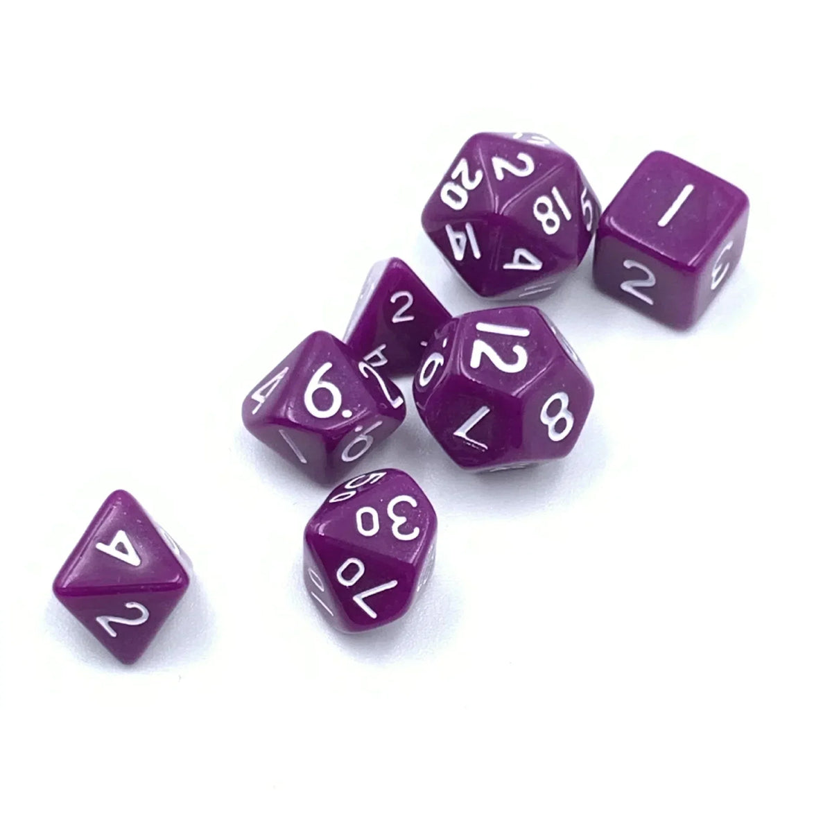 A collection of seven small purple polyhedral dice scattered on a white surface.