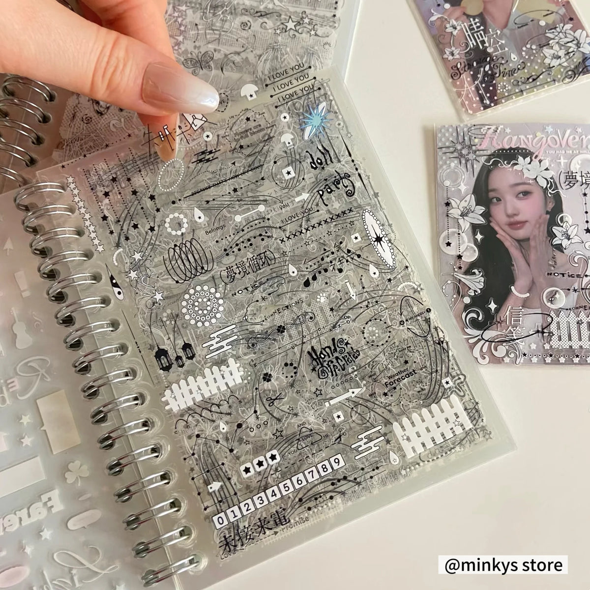 A close-up of a clear sticker book with intricate black line art and decorative elements for journaling and scrapbooking.