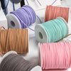 A collection of colorful braided ribbon rolls in various shades including purple, orange, teal, pink, and gray for crafting.