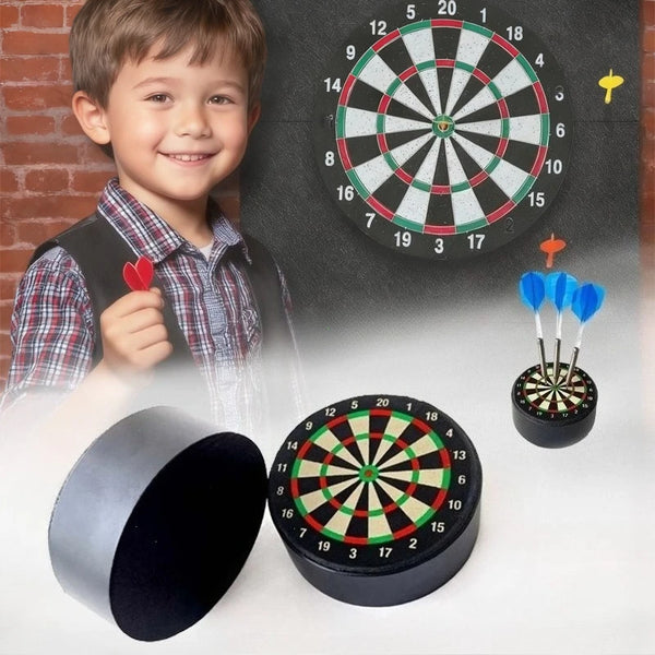 A boy smiling next to a dartboard and several mini foam darts.
