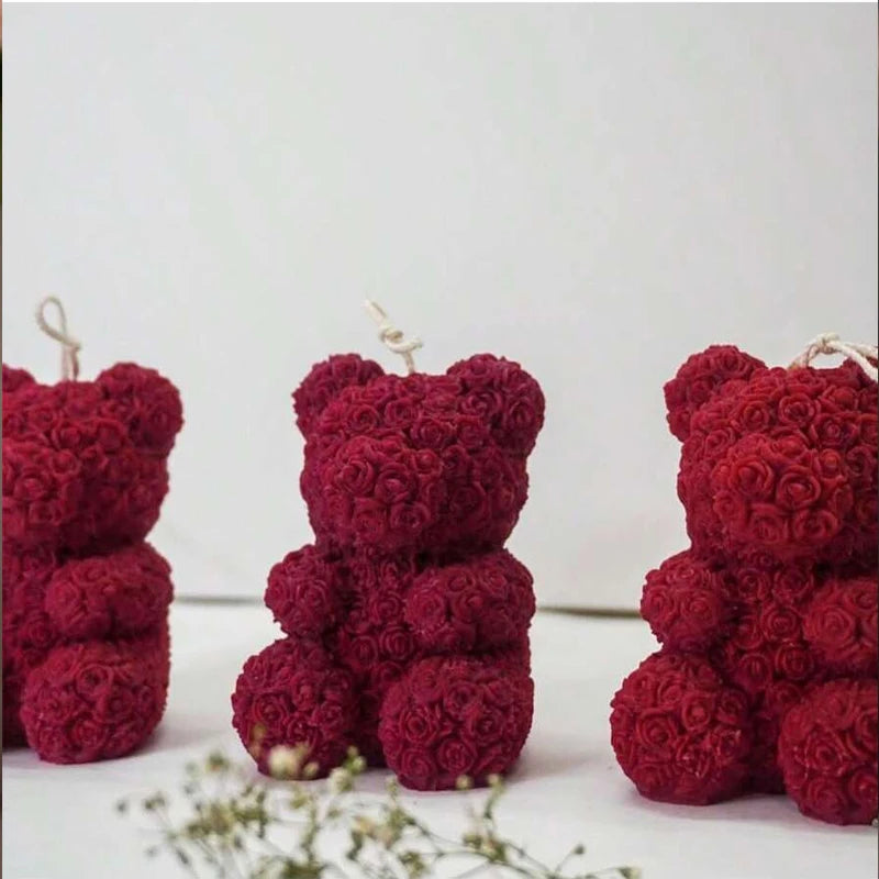 A close-up of a deep red 3D rose bear silicone mold for candle making.