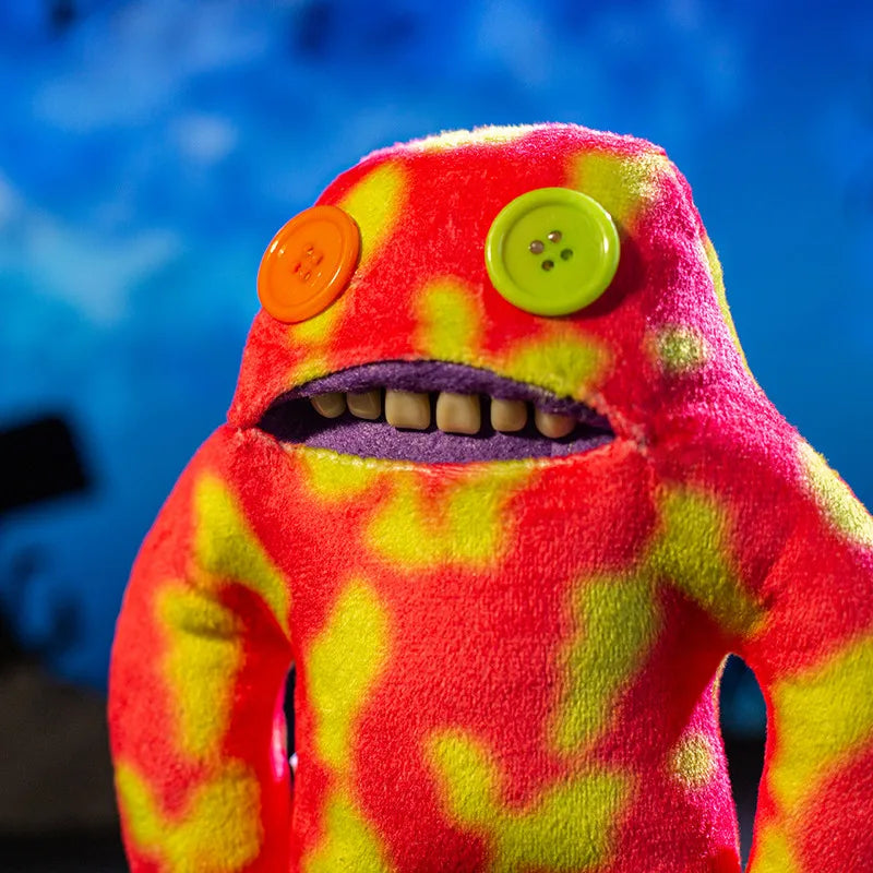 A bright red and yellow plush monster doll with large eyes and visible teeth.