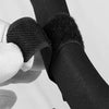A close-up of black universal multi-purpose stroller hooks attached to a leg, held by a hand.