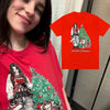 A red t-shirt featuring a Christmas theme with figures and a festive tree design.
