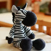 A black and white zebra plush toy sitting on a light surface.