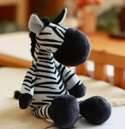 A black and white zebra plush toy sitting on a light surface.