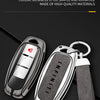 A silver key case cover for an Infiniti model, featuring a two-tone design and attached to a black strap.