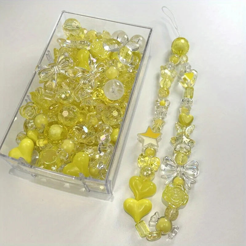 A clear box filled with yellow and clear acrylic loose beads for jewelry making