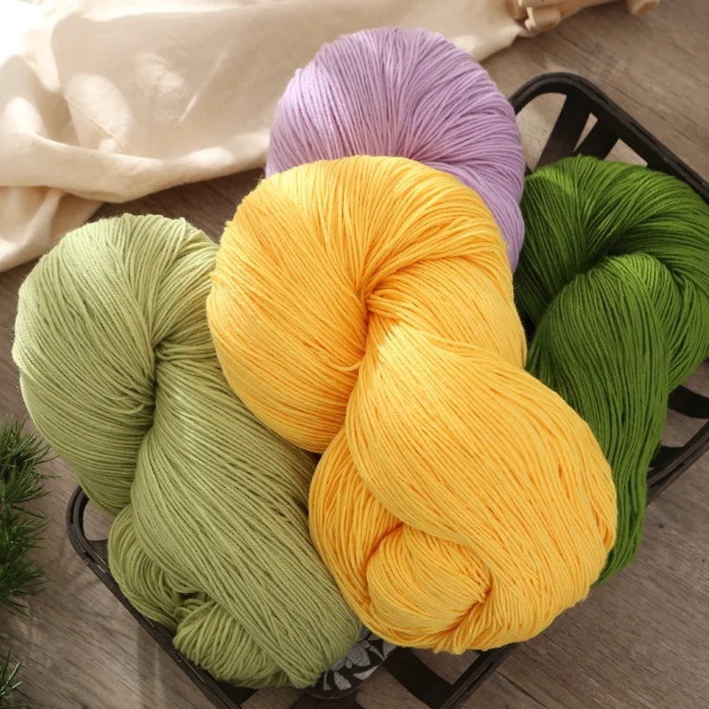 A collection of brightly colored yarn skeins including purple, yellow, and lime green yarns displayed in a dark basket.