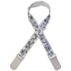 A beige woven guitar strap with blue floral embroidery and leather accents, shown folded.