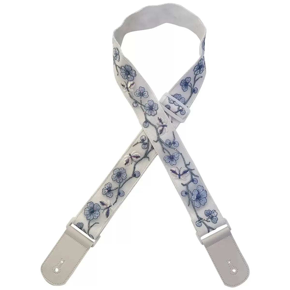 A beige woven guitar strap with blue floral embroidery and leather accents, shown folded.