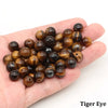 A handful of dark brown Tiger Eye round beads for jewelry making