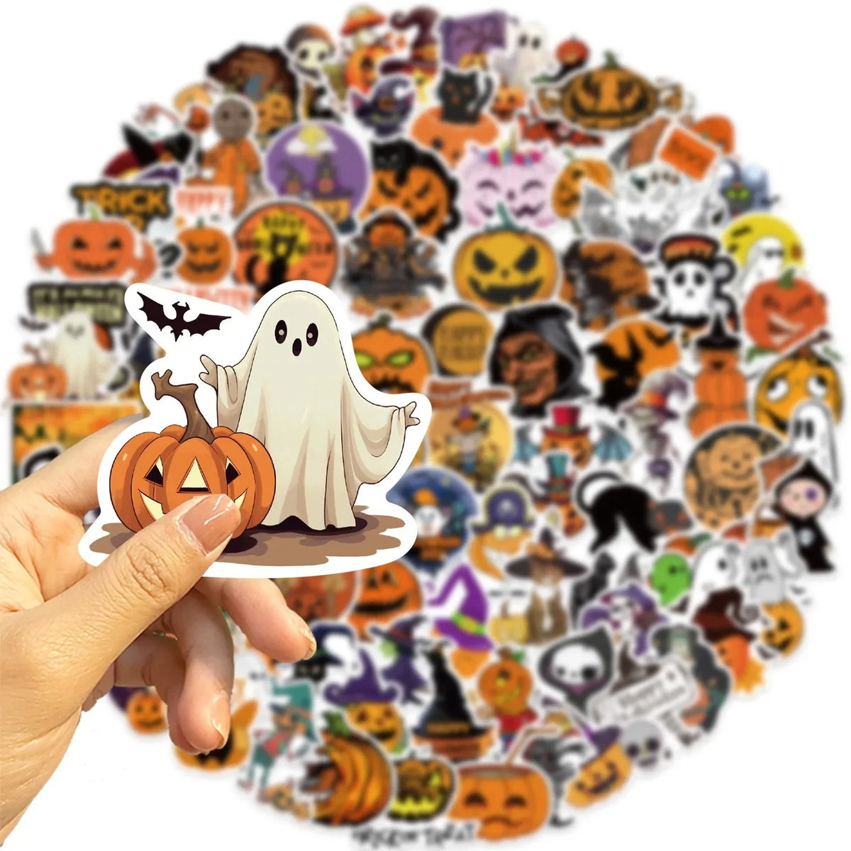 A hand holds a large collection of Halloween-themed waterproof stickers for laptops and bottles.