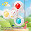 A white spinning bath toy set featuring a rabbit and eggs, demonstrating the rustling sound for auditory development.