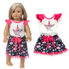 A doll wearing a white top and black skirt outfit set with pink ruffled sleeves and a bow detail.