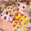 A hand holds a set of miniature pet animal figures in various shades of pink and yellow.