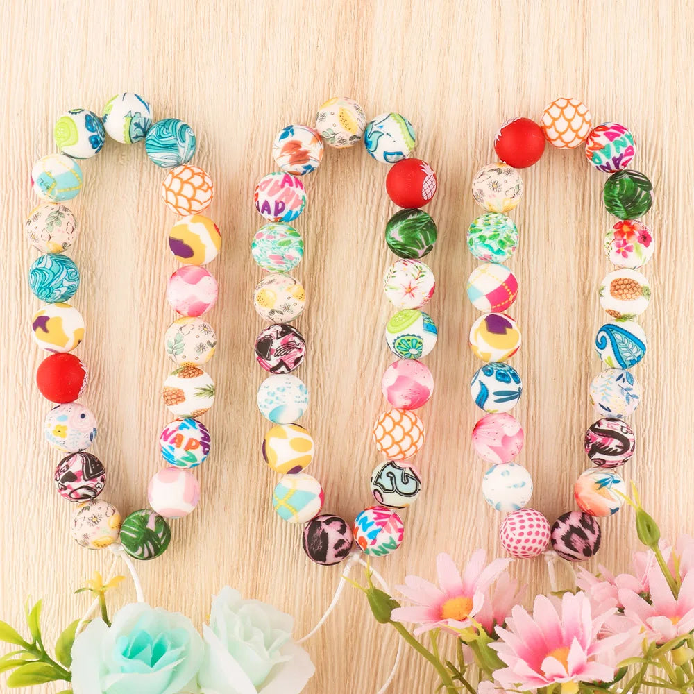 A string of colorful round silicone beads for jewelry making laid out on a light wooden surface.