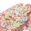 A hand holds a large pile of colorful polymer clay slices for DIY crafts