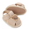 A pair of beige soft cotton baby walking shoes with anti-slip soles and suede toe caps.