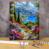 A painting in progress featuring a vibrant landscape with mountains, blue water, and colorful flowers.