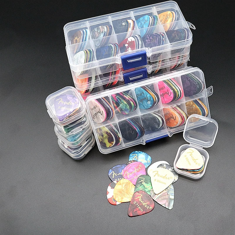 A variety pack of celluloid guitar picks in various colors and shapes is displayed with a clear plastic storage box.