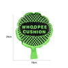A bright green cushion shaped like a tree with a black and green checkered pattern, labeled WHOOPEE CUSHION.