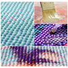 Close-up of a 5D diamond painting kit featuring moonlit tree landscape art with full drill rhinestones in various colors.
