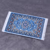 Handwoven Turkish style miniature carpet mat with blue and white patterns on a gray background