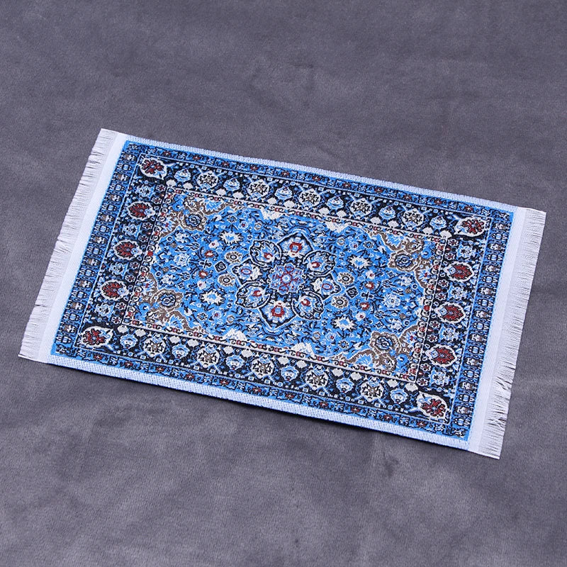 Handwoven Turkish style miniature carpet mat with blue and white patterns on a gray background