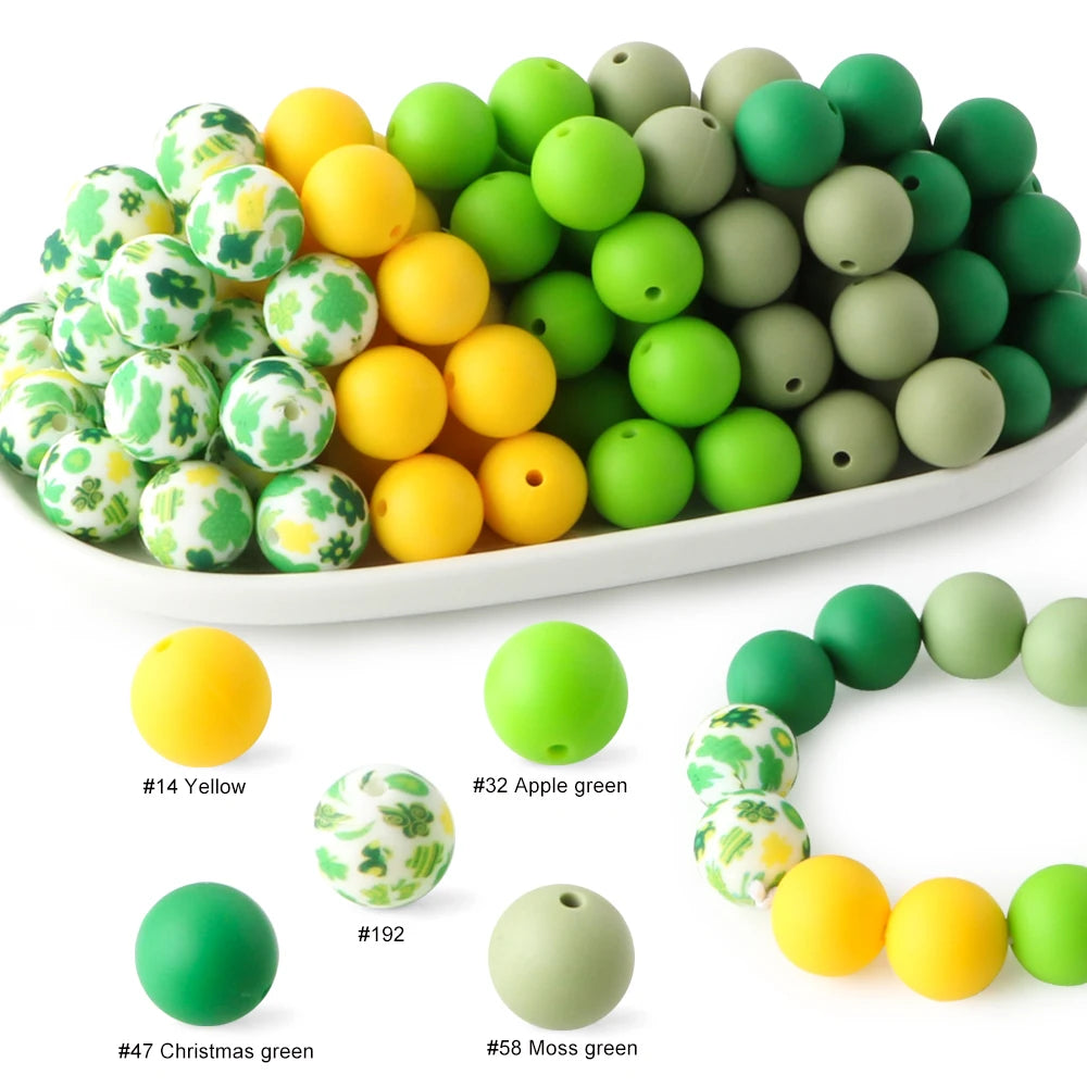 A collection of soft food-grade silicone beads in various shades of green and yellow.
