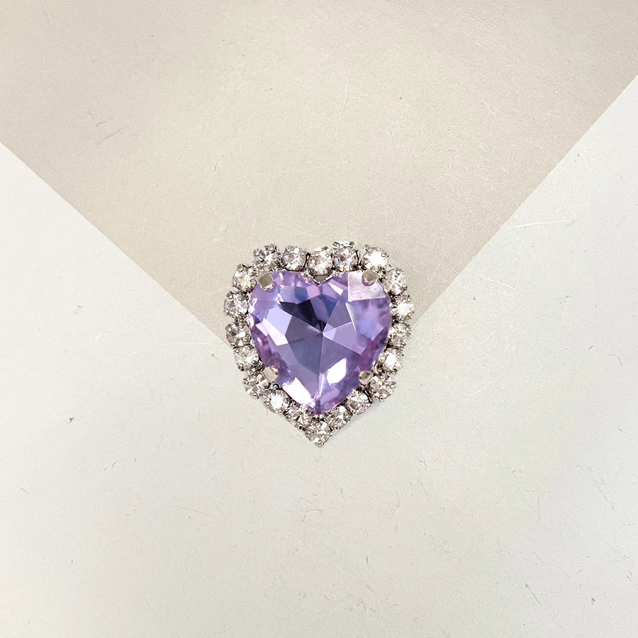A heart-shaped gemstone pendant featuring a purple amethyst stone surrounded by clear rhinestones.