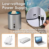 A silver electric heating device for wax melts shown next to a laptop and various power adapters.