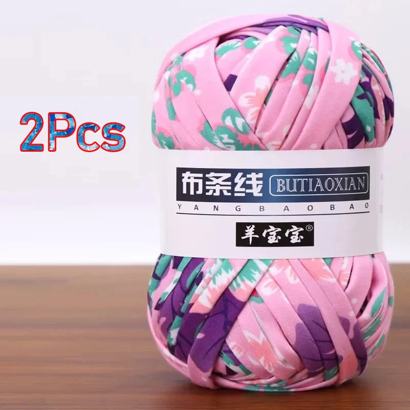 A skein of pink and purple soft chunky t-shirt yarn is shown, packaged as a 2-pack.
