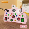 A pink Montessori busy board with various light switches and a bear head topper for toddlers.