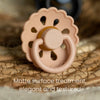 A light beige natural latex baby pacifier with a textured surface resting on a woven background.
