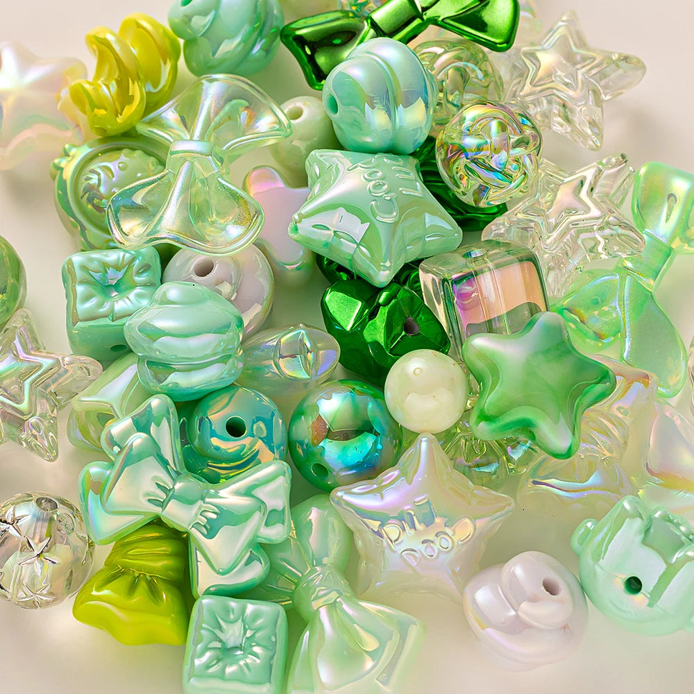 A collection of iridescent green and lime acrylic bow and flower beads for DIY jewelry making