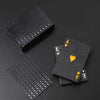 A set of premium frosted poker playing cards with a black gift box displayed on a dark surface.