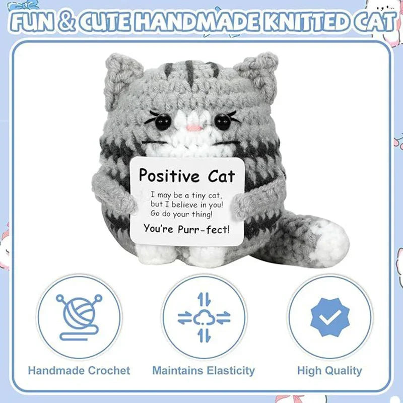 A handmade knitted gray cat figurine with white accents, designed as a cheerful emotional support gift.