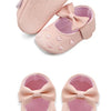 A pair of pink baby girl bow-knot first walker shoes with soft anti-slip soles.