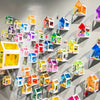 A collection of colorful, transparent PVC sheet houses and models displayed on a gray wall.