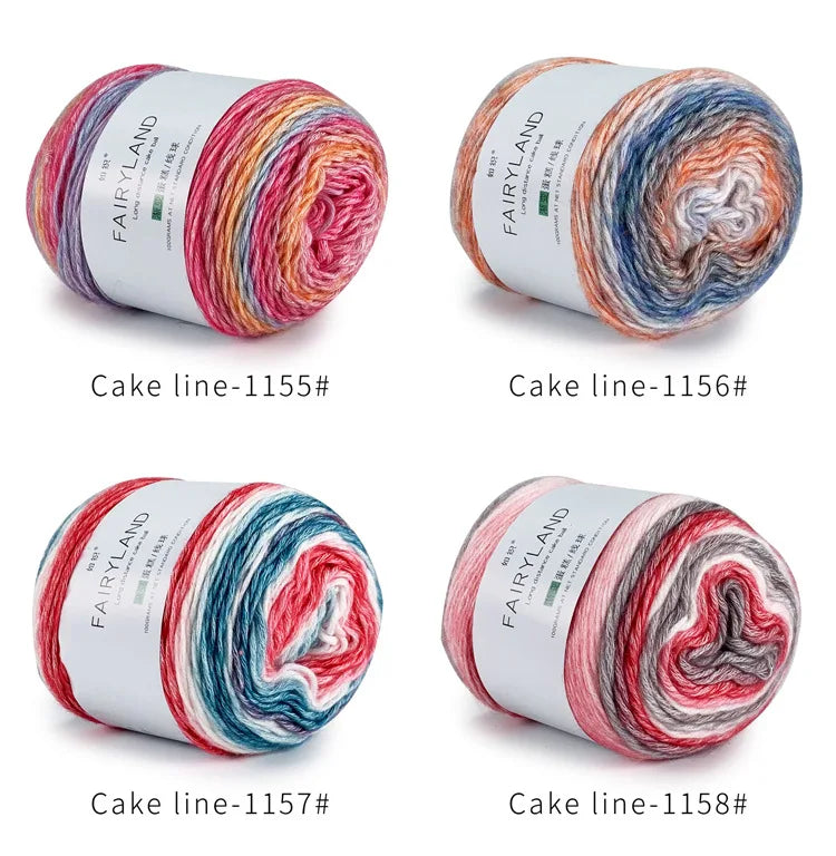 Four spools of Fairyland cake line yarn in various rainbow colors and shades for knitting and crochet