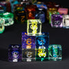 A collection of seven polyhedral resin dice in various colors and sizes arranged on a dark surface.
