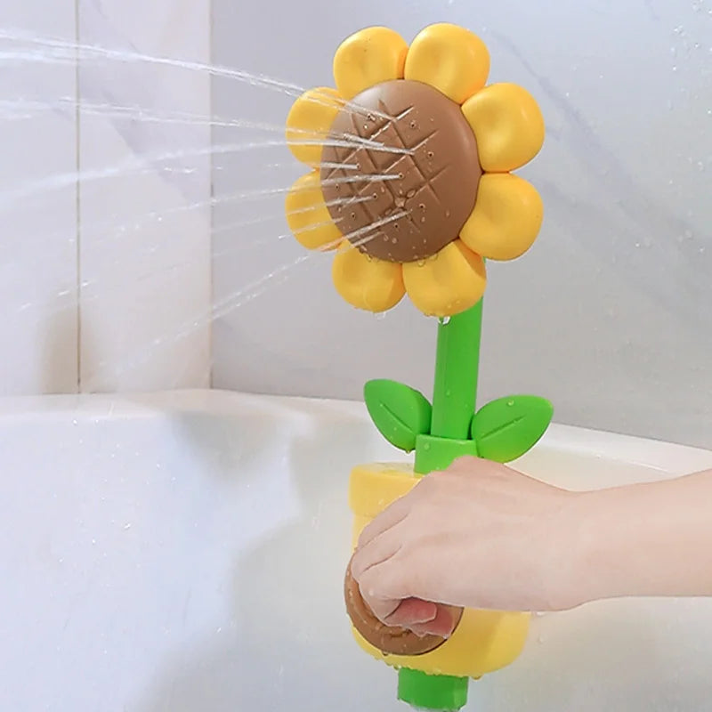 A hand is holding a sunflower bath shower sprinkler toy for kids, which features yellow petals and a brown center.