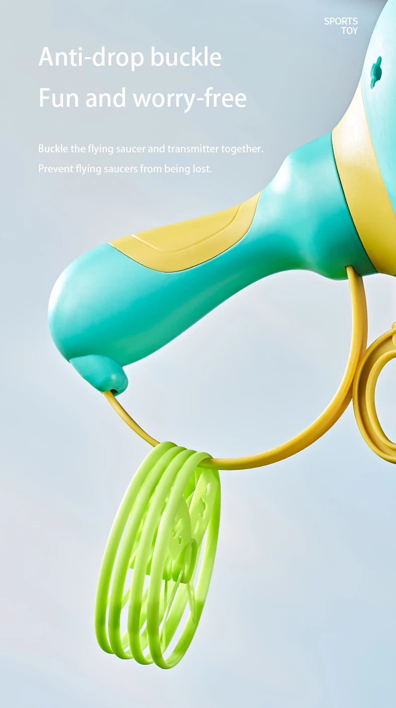 A close-up of a teal and yellow pull-string flying saucer toy launcher with a green string dangling.