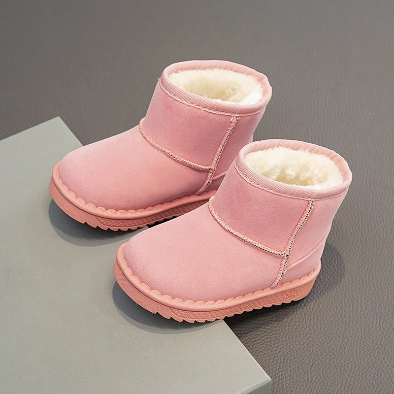 Pink cozy fur-lined winter boots with pink suede material shown on a gray surface.