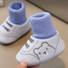 A pair of white baby soft sole first walker shoes with light blue fabric cuffs and anti-slip TPR soles.